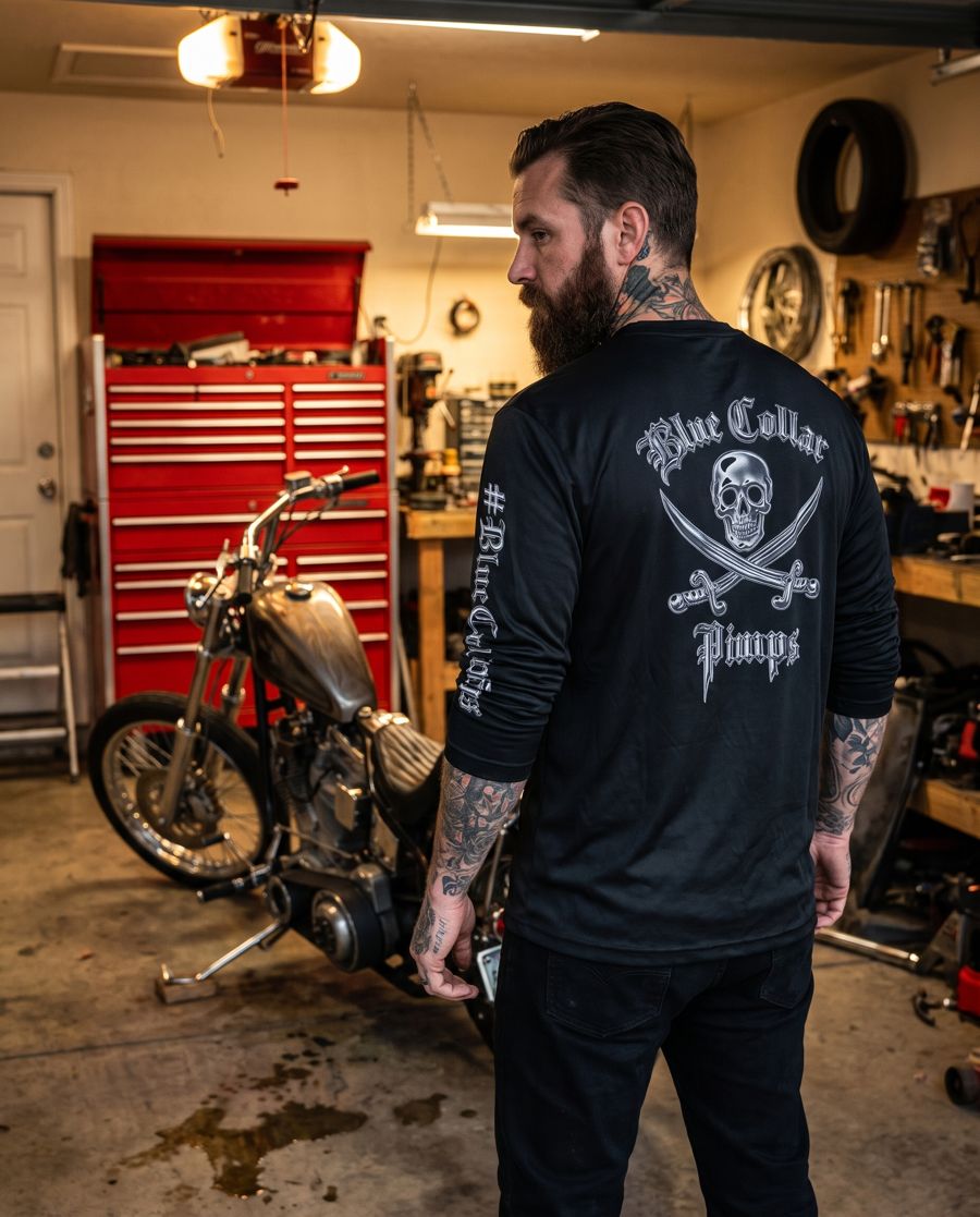 Motorcycle builder in a black BCP long sleeve next to a custom chopper